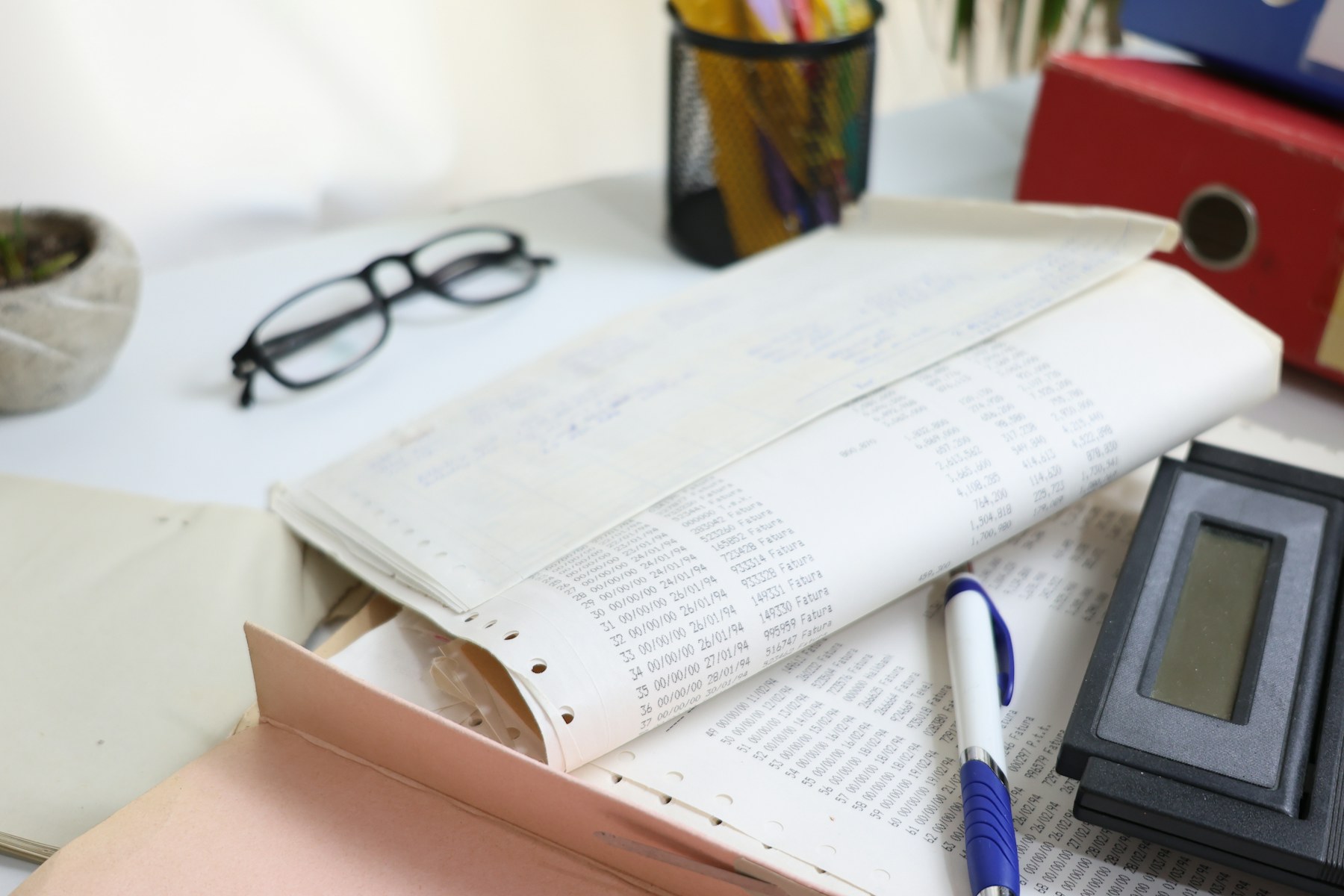 Financial documents, calculator and office supplies on a desk